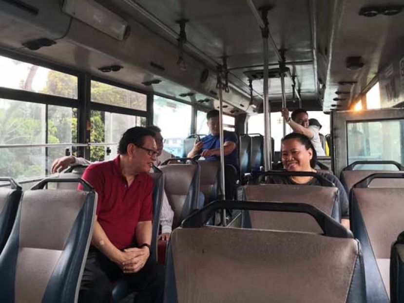 砂交通部长拿督李景胜在诗巫搭乘巴士，向乘客了解巴士运行情况。