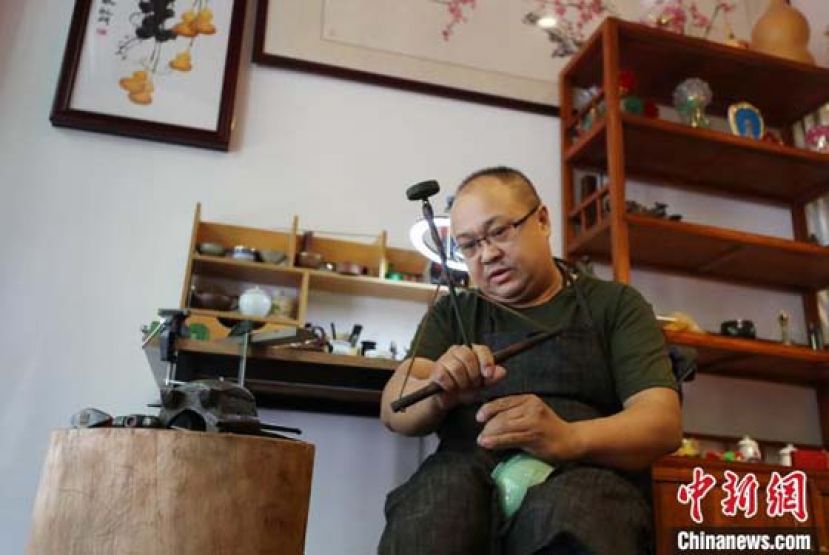 张兵正在用金刚钻为瓷器打孔。