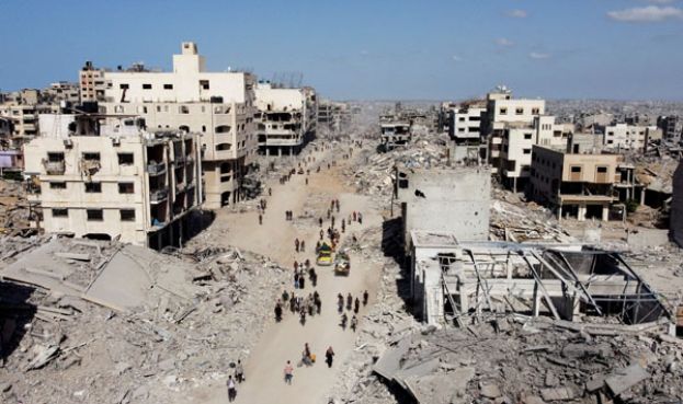 加沙停火协议生效，以军撤出后的空拍画面可见巴勒斯坦人走过废墟。