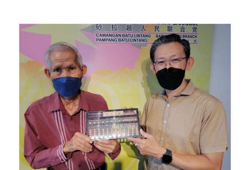 人联党峇都林当支部主席薛华东（右）与方由传（左）展示后者研发的方氏数字转轮算盘。
