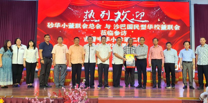 沙巴国民型华校董事会联合会主席林克光（右五）移交纪念锦旗予晋汉连省津贴华小董联会会长兼古晋中华小学校董会主席拿督蔡文铎律师（右七）。右六为砂拉越津贴华小董事联合会主席拿督包章文。左七为二小副主席张光福、左八为晋汉连省津贴华小董联会署理会长兼古晋中华小学校董会秘书长田松茂。