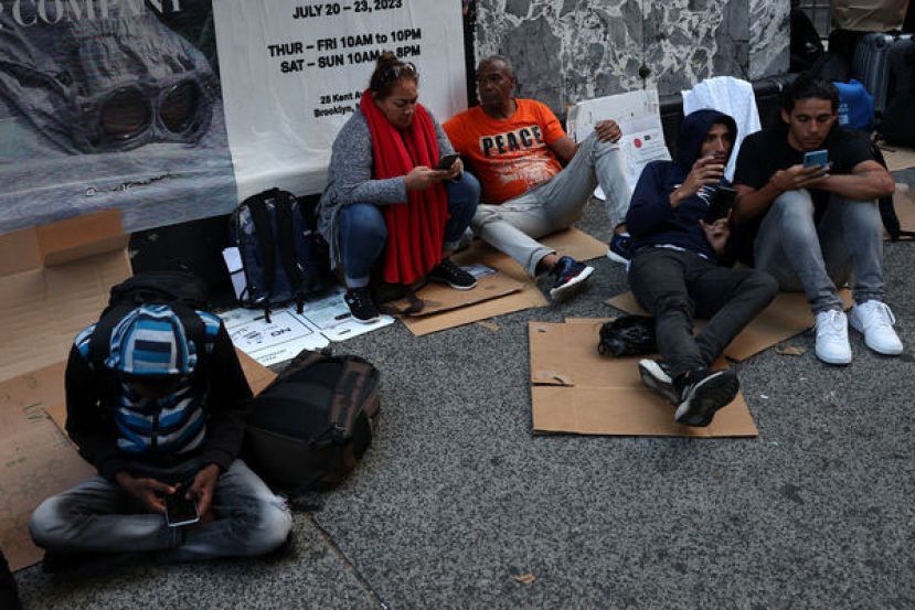 纽约曼哈顿涌入移民排队等待收容床位。