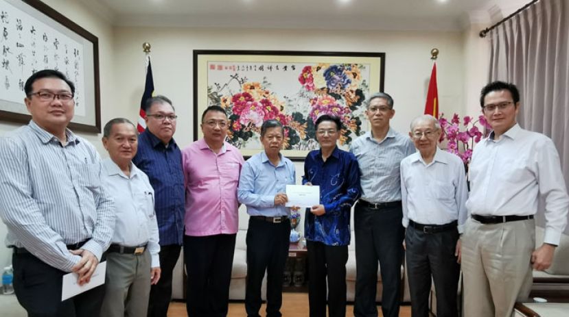 古晋中总会长、砂中总署理会长、砂中友好协会副会长拿督陈日枝（左5）移交捐款予中国驻古晋总领事程广中，左起为砂中友好协会财政、古晋中总数字经济组副主任王运才博士、古晋中总福利组主任何金明、黄文彬集团董事、砂中友好协会副会长、古晋中总副会长拿督黄国辉、砂中总副会长、古晋中总秘书长蔡文铎律师、中国驻古晋副总领事张阳、古晋中总署理会长、砂中总秘书长、砂中友好协会秘书李锦新及砂中总理事、古晋中总财务组主任何修华。