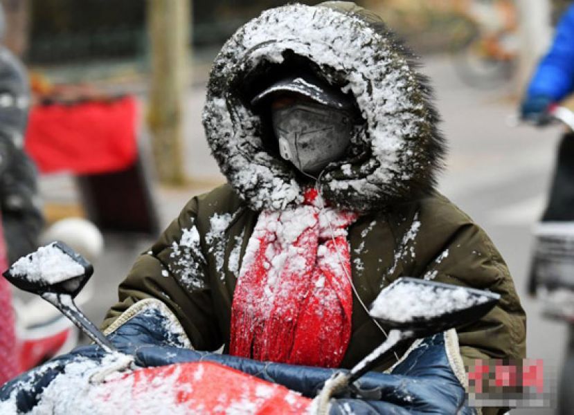 图示：一位市民的衣帽被雪&ldquo;覆盖&rdquo;。
