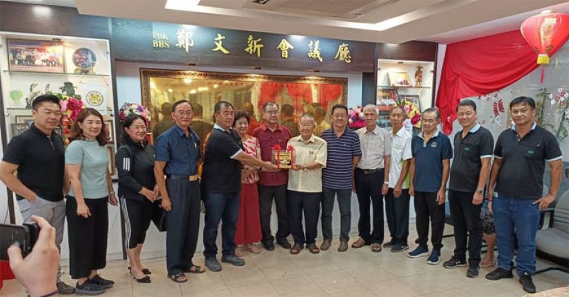 砂云南善堂副主席钟名宝（右7）在众人陪同下，赠送纪念品給KFF Group of Companies董事郑汉彬，以示感谢。