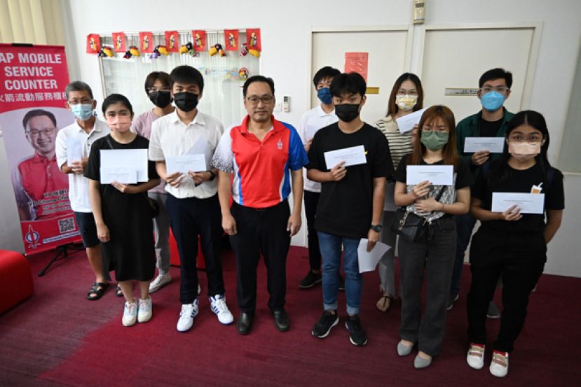 首批10名喜获实旦宾国会选区高等教育助学金的受惠学子们及代领的家长与实旦宾区国会议  员张健仁（左五）合影。