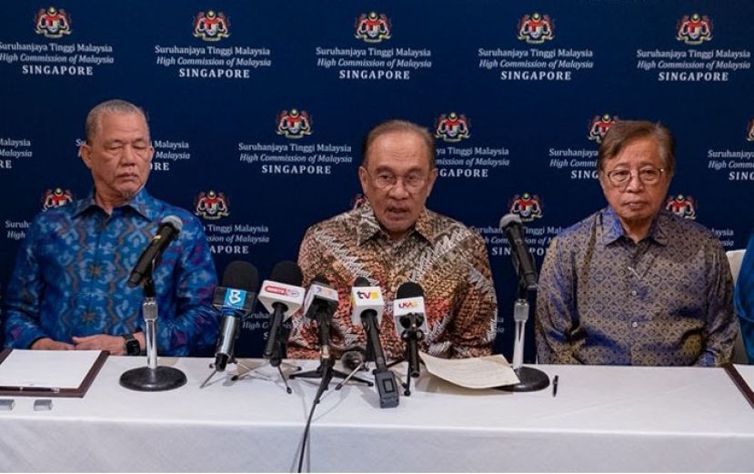 首相安华(中)在新加坡向大马媒体发表谈话。左为副首相法迪拉和砂总理阿邦佐哈里(右)。