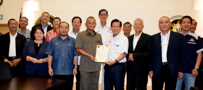 天猛公杨惠生(左四)从李景胜手中接过美里省华人社区最高领袖的委任状。(左三)是省长慕斯达化，(右起)为尼丹斯州议员、俞小珊及陈超耀州议员。