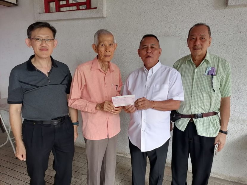 甲必丹林传政（右2）由方由传（左2）手中接过建造亚答街大树底下拿督公神龛公园处亭子赞助经费；左为见证者薛华东；右是孙守生。