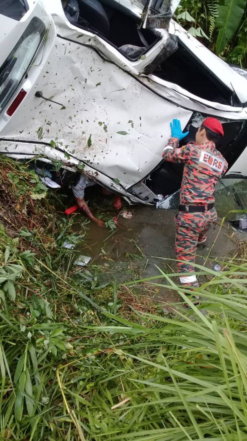 轿车失控撞入沟酿一死一重伤惨剧，图为消拯员正在设法救出死伤者。