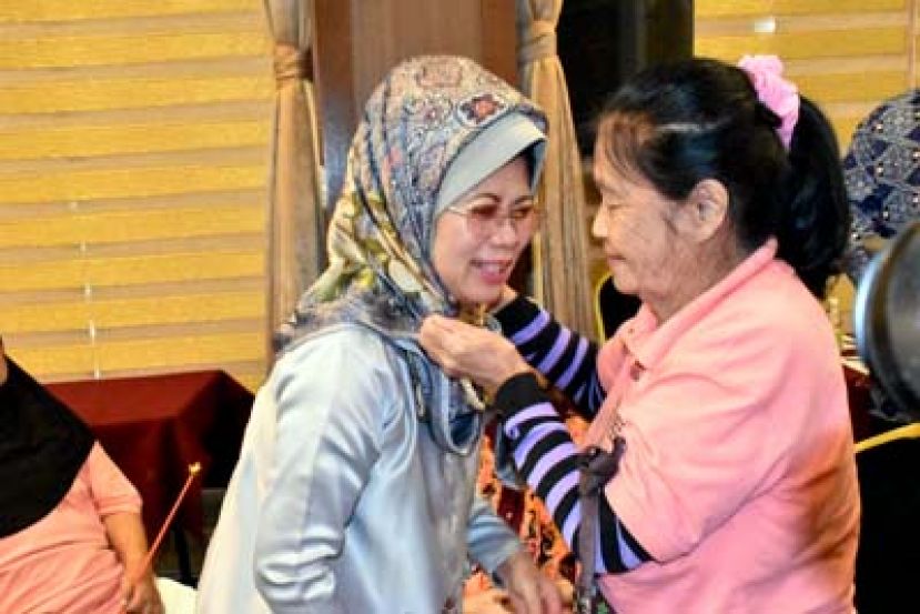 乐龄人士为砂福利、社会和谐、妇女、家庭与学前教育发展部部长拿督斯里法蒂玛陈赛明献上珠串项链。