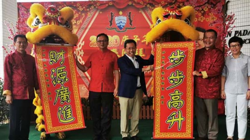 砂拉越地方政府与房屋部长拿督斯里沈桂贤（右三）及巴达旺市议会主席罗克强（左二）从瑞狮口中接过春联。