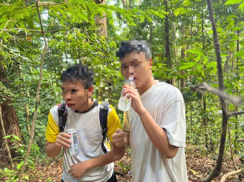 2名少年获救后喝饮料补充水分。