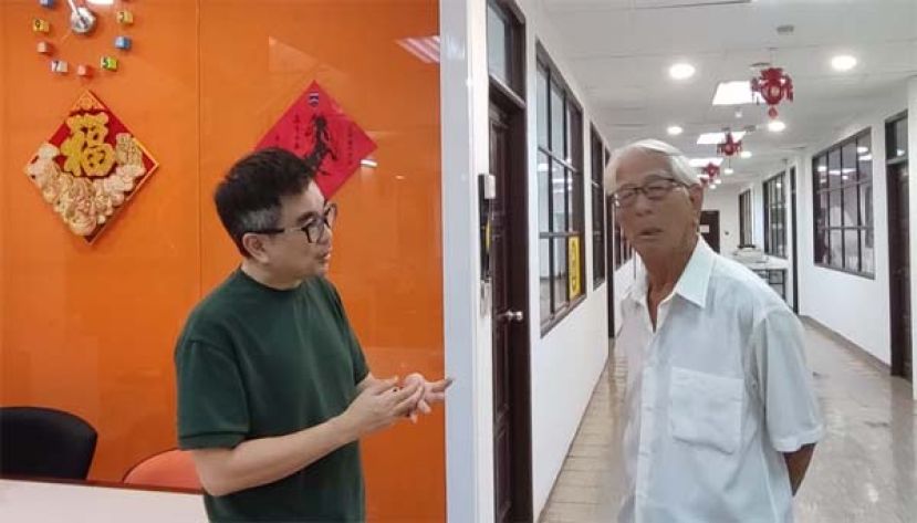 因未获批准不得在党总部召开记者会，方镇鸿（右）和职员交谈时影。
