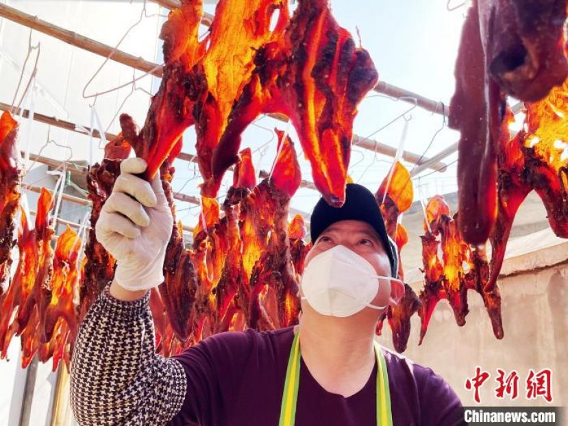 张福光检查&ldquo;腊猪头皮&rdquo;风干情况。