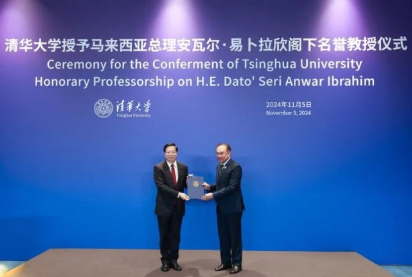 安华（右）在邱勇教授手上接过名誉教授聘书。