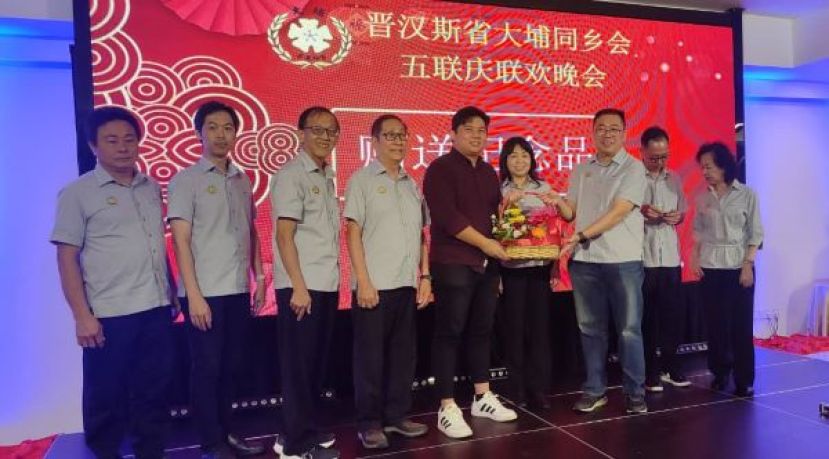 王恭宇（中）代表不克出席的张健仁移交支票，并由公会主席罗绍凤接收时影。