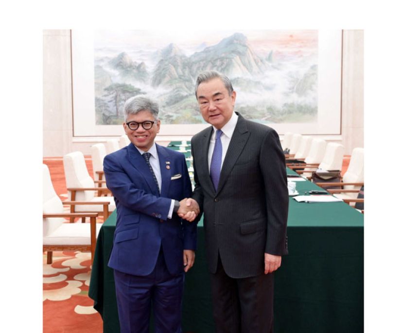 大马国家安全理事会总监拿督诺希万(左)与王毅亲切握手。