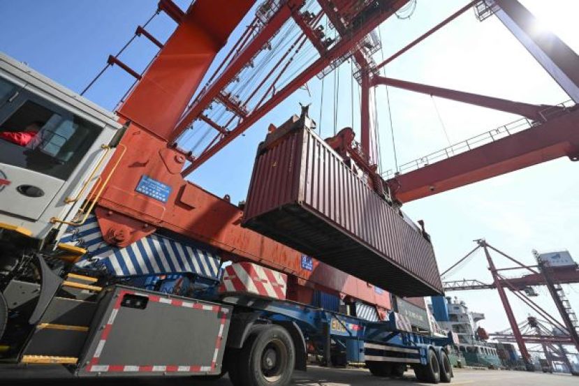 一台起重机15日正在中国江苏省张家港将货物装载到船上。