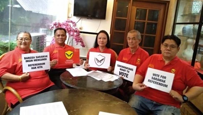 砂民志党总裁徐丽娜（中）向媒体展示该党新党徽。