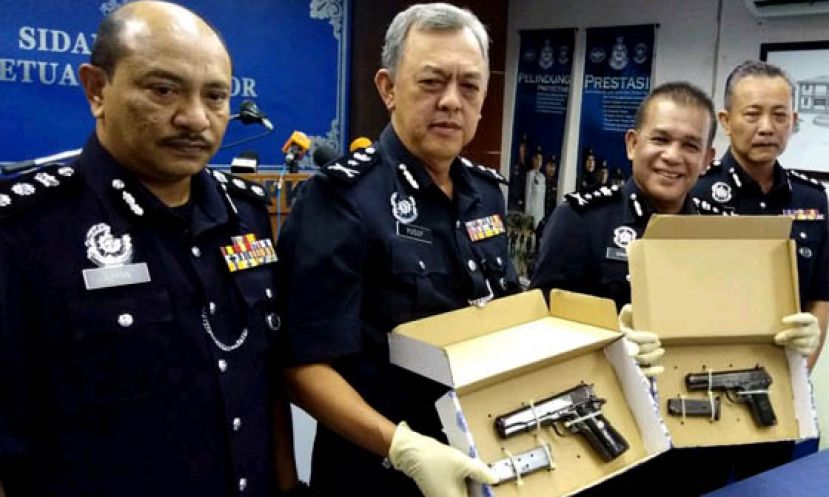 柔佛副总警长拿督沙菲益(左二)展开所起火的手枪和子弹。