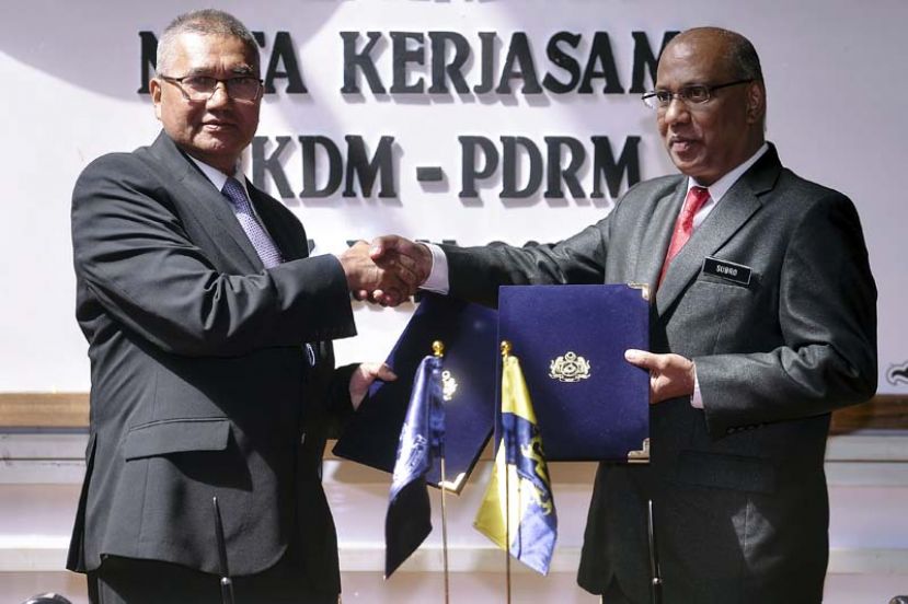 图：全国警察总长丹斯里弗兹(左)和关税局总监拿督斯里苏伯马念交换合作协议书。