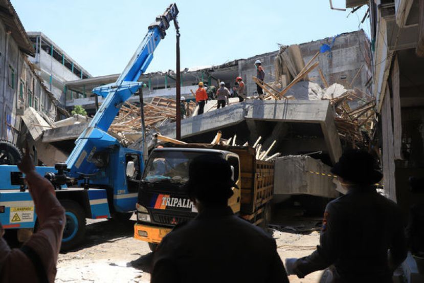 寄宿学校倒塌后，搜救团队寻找生还者，清理现场瓦砾与残骸。