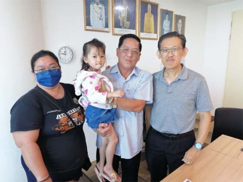 天猛公陈如飞（中）抱着申请临时证件5岁无国籍女童陈艳诗给予勉励；右是人联党中央副主席薛华东；左为该女童婆婆梭玲。