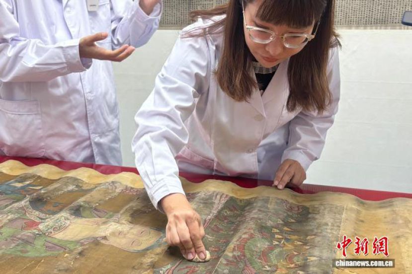 修复师用制作莜面团的传统方法对灰尘污渍严重的书画进行粘附除尘。