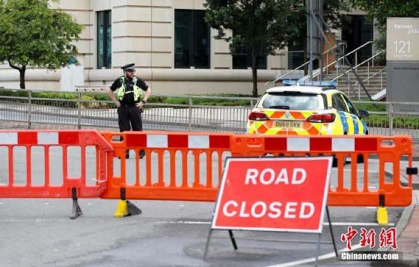 图为当地时间6月21日，在英国雷丁，警察在持刀袭击事发地警戒。