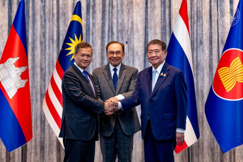 泰国代首相普坦(右)与柬埔寨首相洪马奈(左)握手言和，中为大马首相安华。