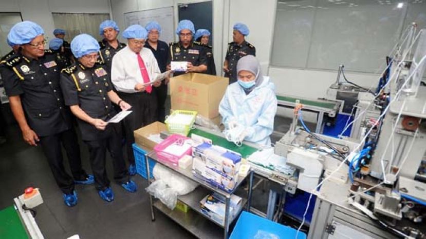贸消部副秘书长阿劳丁（左3）参观巴生一家口罩制造厂，左2是该部执法主任拿督依斯甘达哈林。