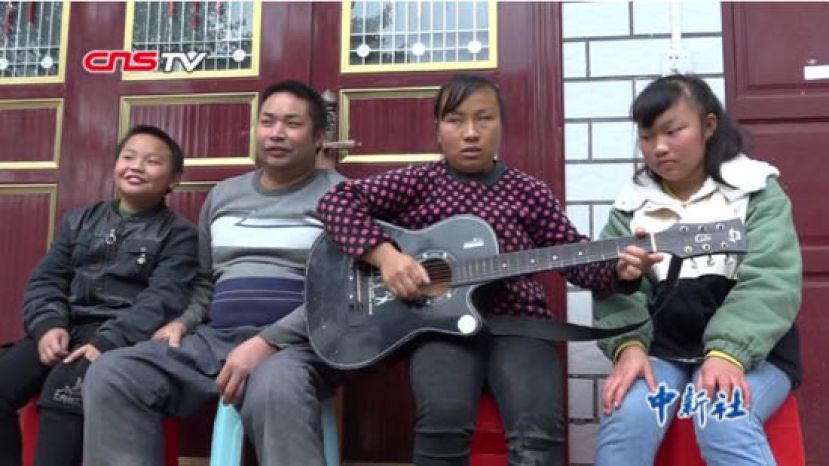 家人坐在杨小艳身边听歌。