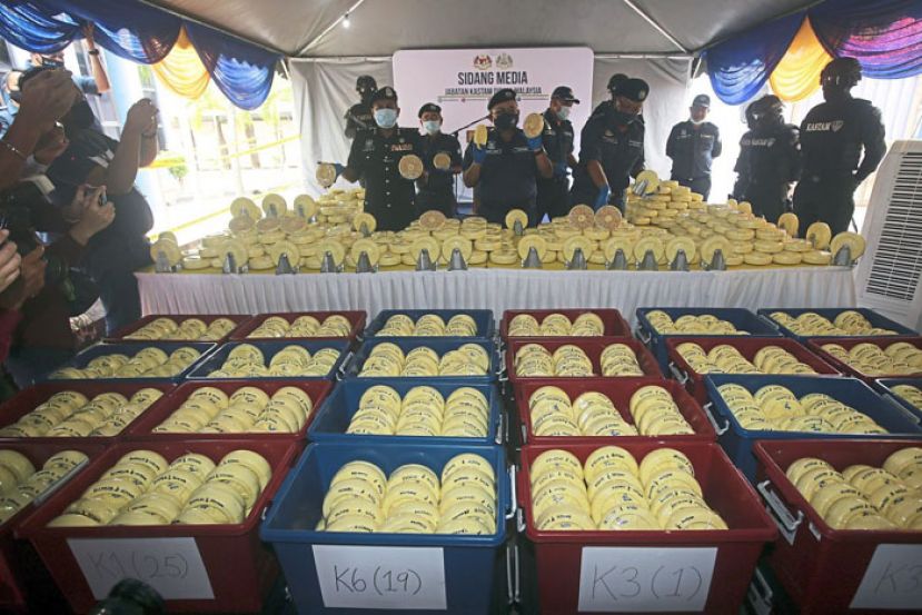 阿都拉夫（中）与官员展示藏在滑轮中的毒品。