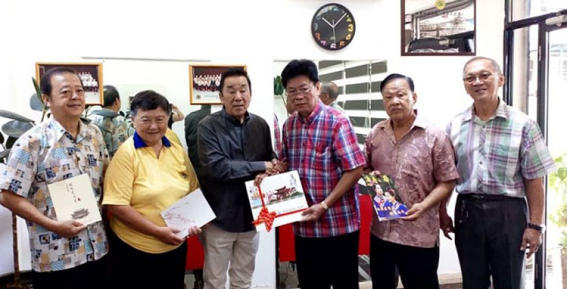 古晋兴安会馆会长黄张金发（左三）赠送刊物予雪隆海南会馆（天后宫）秘书长黄良友（右三）时摄。左二为天后宫主任郭玉梅。左一为监察方睦斌。右二为顾问郑瑞福，右一为古晋海南公会名誉顾问陈华勉。
