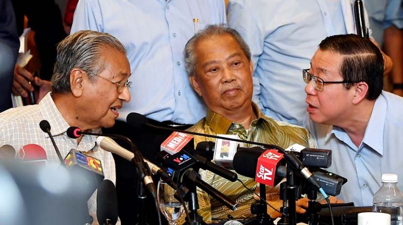 图：敦马哈迪和林冠英在希盟最高中央理事会会议后召开记者会上交换意见，中为丹斯里慕尤丁。