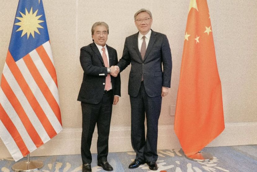贸工部长佐哈里（左）与王文涛亲切握手。