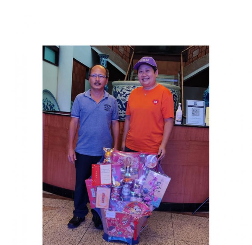 古晋爱心书协会主席吕晗韵（右）移交新年礼篮，由国际时报助理总编辑林甲昌（右）接收。