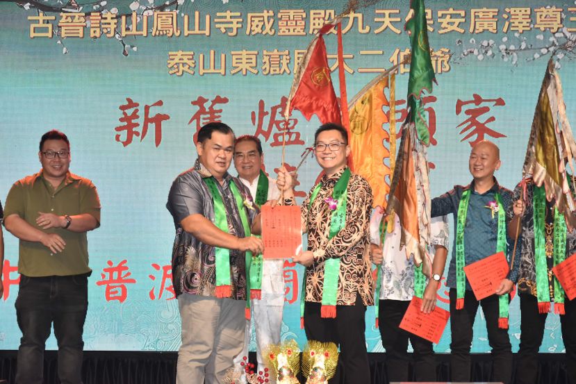 在庙主何国华（中）见证下主席郑永涂（左）移交信物予2026年丙午年炉主刘儱语（右）。