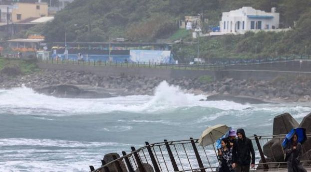 台风&ldquo;凤凰&rdquo;10日逼近台湾基隆市，人们撑伞抵挡风雨。