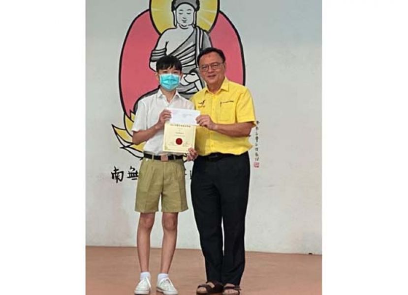 巴都吉当区州议员兼巴达旺市议会主席罗克强(右)颁发奖励金给获奖学生。