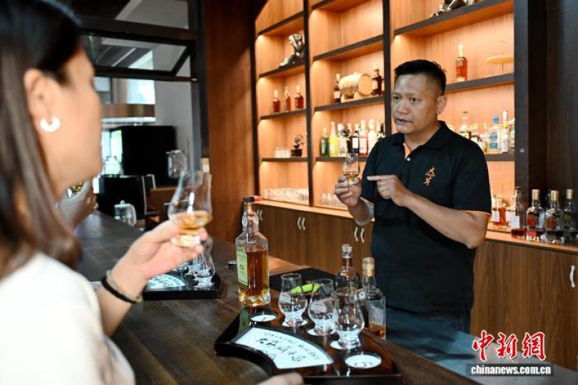 在福建漳州平和大芹山酿酒的台胞邱正贤，为游客介绍如何品鉴威士忌。