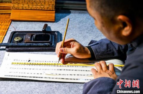 湖北荆州楚韵阁内，黄有志在竹简上摹写。