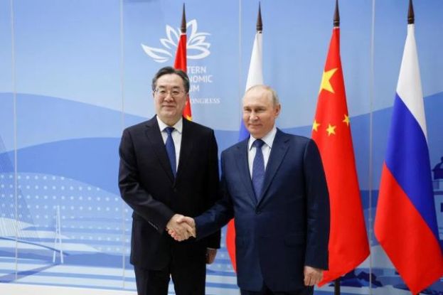  俄罗斯总统普京（右）在东方经济论坛期间，与中国国务院副总理丁薛祥举行场边会时握手。