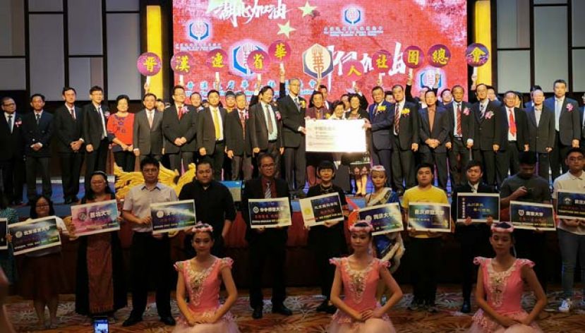 晋汉连省华总会长拿督黄良杰（右八）移交华总捐献的第一笔捐款10万7500令吉予中国抗击新冠肺炎基金，由中国驻古晋副总领事张阳（左十一）接收。