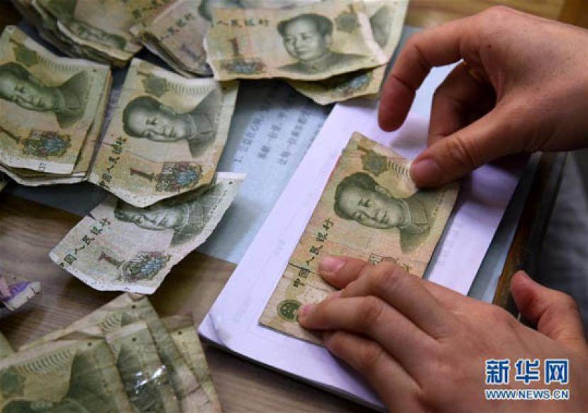 图示：孙霞在修补残币。