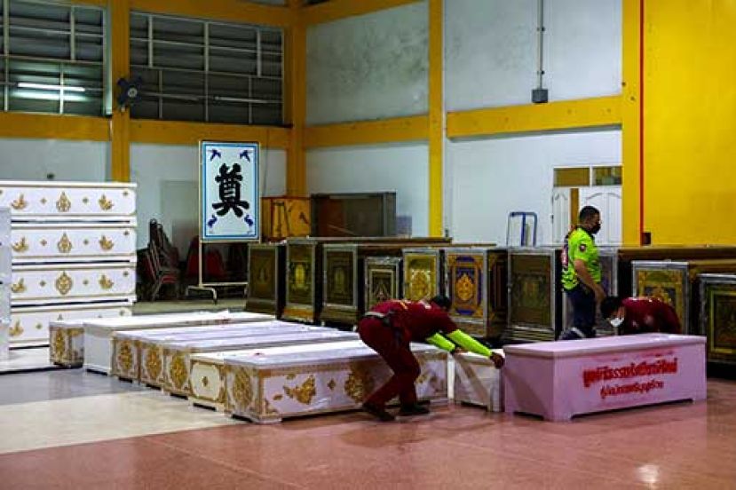 ●救援队将小棺木一一搬上卡车，运往冰柜冰存。