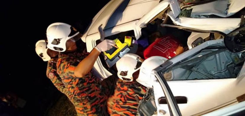 消拯人员正设法锯开车子残骸，以移出司机及妻子的身躯。