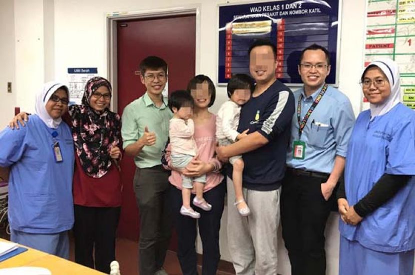 女童父母抱着孩子，在离开医院前，与医护人员合照，以感激他们的细心照顾。（图取自诺希山面子书）