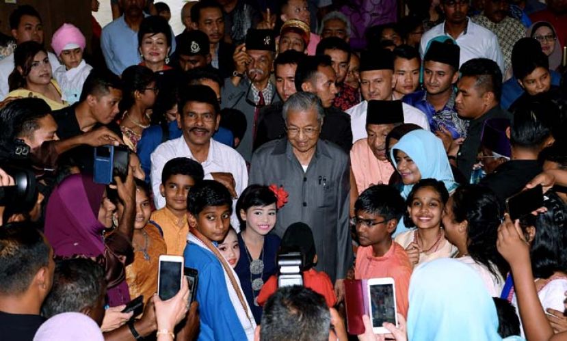 图：首相敦马哈迪在槟城团结日活动上与出席的各族民众合影。